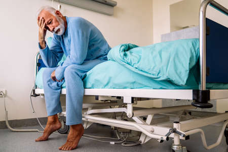 Senior male patient in hospital bed who is recovering from the disease. Healthcare concept.
