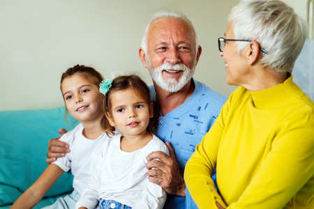Caring granddaughters hugging grandfather supporting him after medical surgery in hospital wardの写真素材