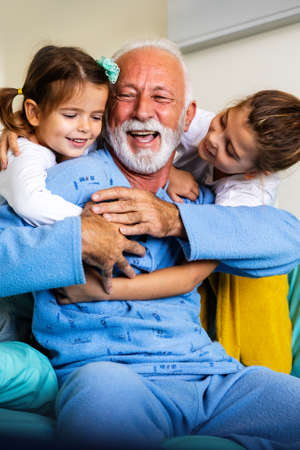 Happy laughing grandfather playing, having fun with his grandchildren together.の写真素材
