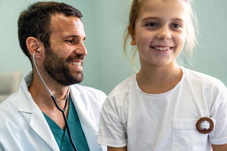 Pediatrician doctor examining little girl in a clinicの写真素材