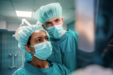 Medical doctors looking at x-rays in a hospital before operation. Healthcare, medical conceptの写真素材