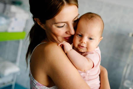 Happy cheerful family. Mother and baby kissing, laughing and huggingの写真素材