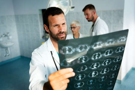 Group of doctor looking at ct scan at hospital to make diagnosisの写真素材