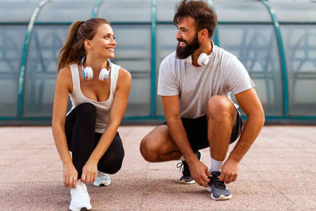 Happy runner couple exercising outside as part of healthy lifestyle. People sport running conceptの写真素材
