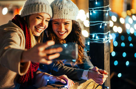 Festive christmas fair concept. Happy women having fun and shopping, enjoying on christmas market.
