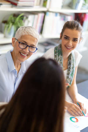 Portrait of happy success business women talking and having fun in office