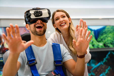 Couple enjoying with VR goggles at tech store. Shopping virtual reality people concept