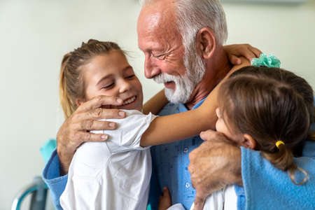 Happy grandfather is recovering from the coronavirus is visited by his grandchildrenの写真素材