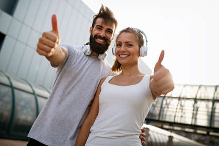 Happy runner couple exercising outside as part of healthy lifestyle. People sport running conceptの写真素材