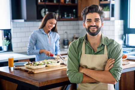 Portrait of happy couple cooking together in the kitchen at home.の写真素材