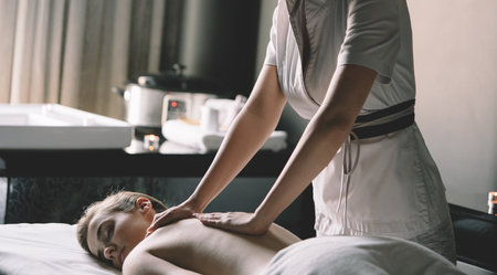 Masseur doing massage on woman body in the spa salonの写真素材