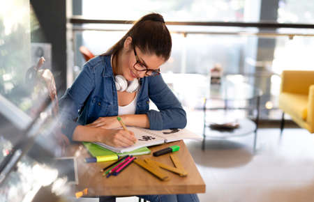 Portrait of happy young female studying in a library. Education study teenager concept