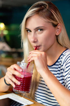 Young woman having a good morning healthy smoothie drink made of super foods. People health conceptの写真素材