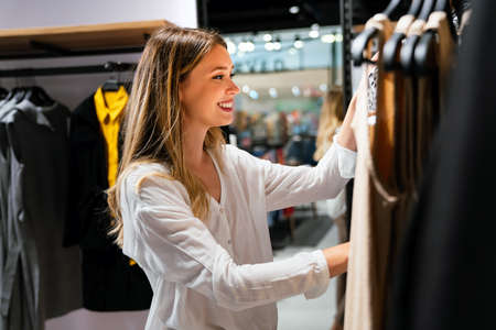 Portrait of beautiful young woman enjoying shopping in store. People consumerism sale concept.