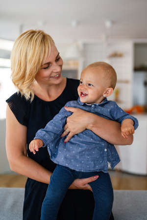 Family, child and parenthood concept. Happy smiling young mother with little baby at home