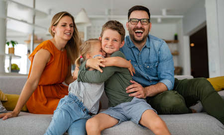Happy family having fun time at home. Parents playing smiling with childrens together.