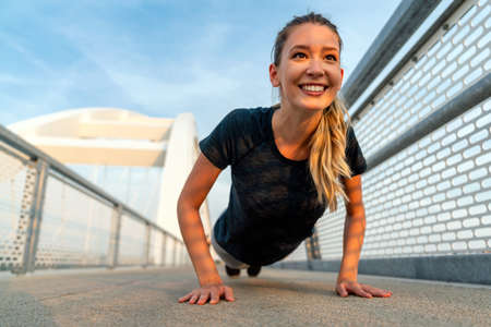 Young sport woman stretching and preparing to run outdoors in city