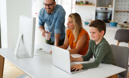 Happy family parent and child at home working on the computer. Business online work home concept.