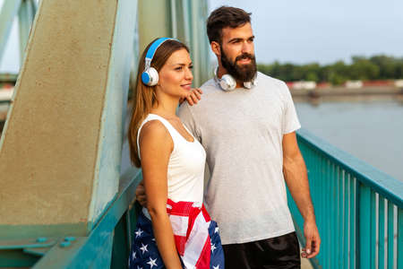 Portrait of beautiful young fit couple with USA flag. Sport people success healthy lifestyle conceptの写真素材