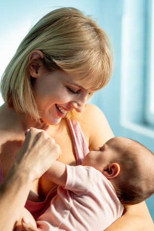 Happy cheerful family. Mother and baby kissing, laughing and huggingの写真素材