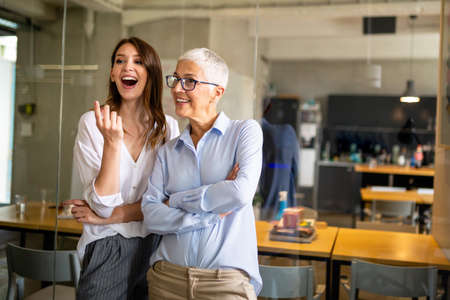 Attractive businesswoman having fun conversation with colleague during break in office