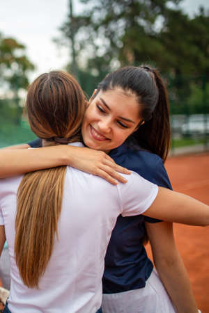 Portrait of fit happy women playing tennis together. People sport conceptの写真素材