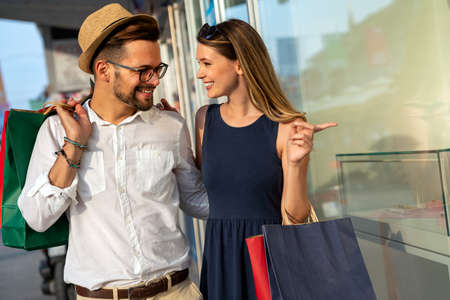 Portrait of a couple with shopping bags in the city. People sale love and happiness concept.の写真素材