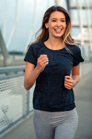 Portrait of young fit attractive happy fitness woman in city. People healthy lifestyle concept.の写真素材