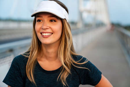 Fitness sport training and lifestyle concept. Happy fit woman running outdoors in city.の写真素材