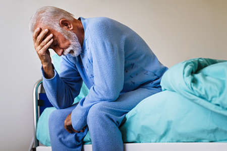 Senior male patient in hospital bed who is recovering from the disease. Healthcare concept.の写真素材