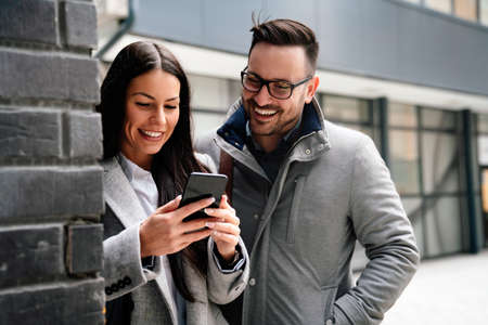 Portraite of handsome man and beautiful woman as business partners working talking outdoor