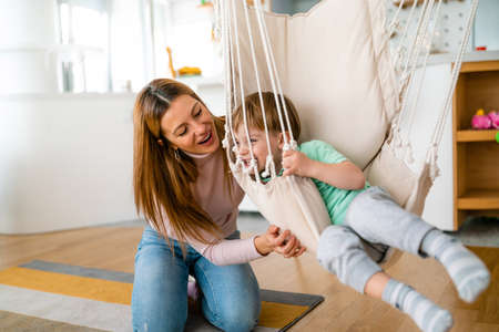Happy little toddler boy having fun with his mother at home. Single parenting, happiness concept.の写真素材