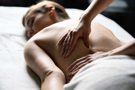 Wellness, spa, health and massage concept - beautiful woman having massage in salonの写真素材