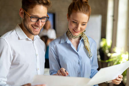 Working on new project together. Group of happy business people cooperating as a team in office