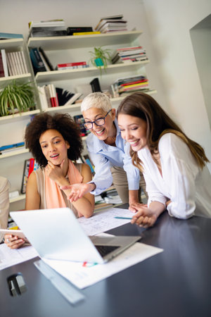 Group of happy successful women colleagues working together on meeting in corporate officeの写真素材