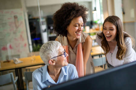 Group of software engineers working developing applications together in corporate officeの写真素材