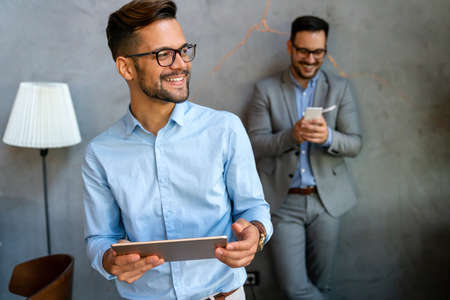 Diverse business people colleagues laughing having fun with digital gadgets in office.