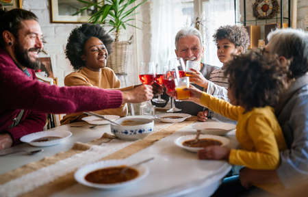 Cheerful multigeneration family spending good time together around kitchen table.の写真素材