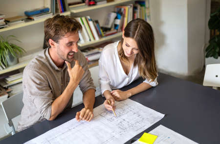 Group of business people on meeting with construction engineer architect looking blueprint plans