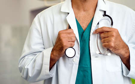 Doctor holding stethoscope in hospital. Healthcare workers, coronavirus and insurance concept.