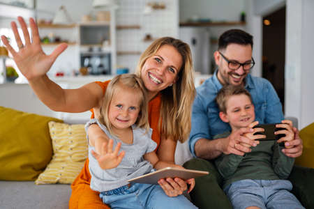 Device technology family online education concept. Happy family with digital devices at home.の写真素材