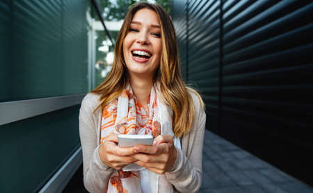 Beautiful business woman using mobile phone outdoors. People communication technology concept.の写真素材