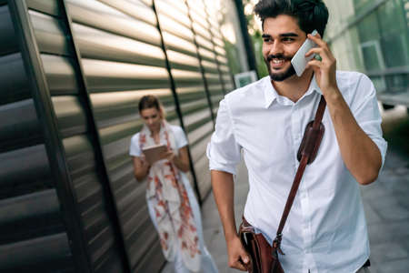 Portrait of successful happy cheerful young business people talking, walking outdoorsの写真素材