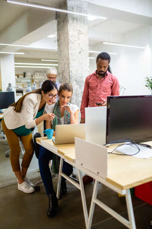 Group of happy multiethnic business people having fun and chatting at workplace officeの写真素材