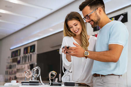 Technology people smart devices concept. Happy couple buying new smart watch in tech store.の写真素材