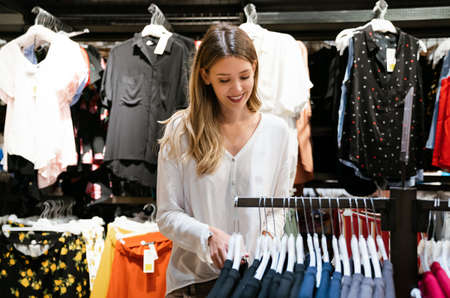 Portrait of beautiful young woman enjoying shopping in store. People consumerism sale concept.