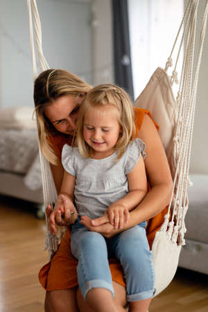 Love family parenthood childhood concept. Beautiful mother and her kid playing together at homeの写真素材