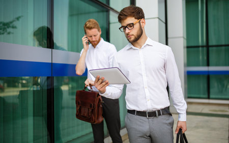 Two successful business men walking outdoors. Business, friendship, communication conceptの写真素材