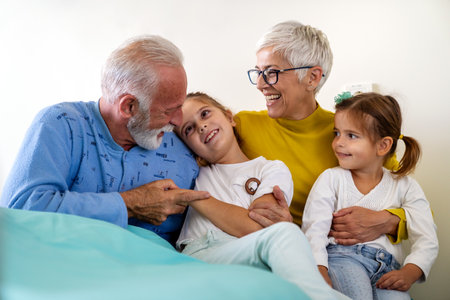 Caring granddaughters hugging grandfather supporting him after medical surgery in hospital ward