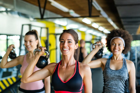 Multiethnic group of people training in a gym. Trainer and sportive fit persons exercisingの写真素材